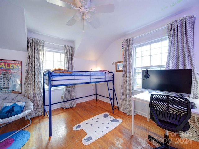 bedroom with hardwood / wood-style flooring, ceiling fan, multiple windows, and lofted ceiling