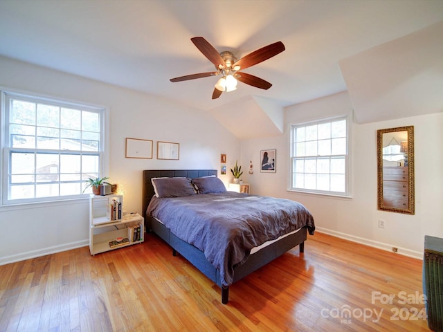 bedroom with ceiling fan, multiple windows, light hardwood / wood-style flooring, and lofted ceiling