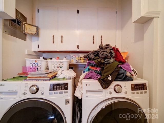 laundry area with separate washer and dryer and cabinets