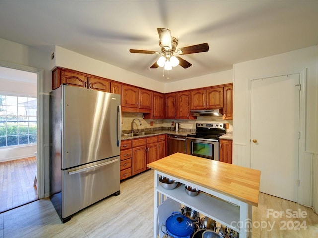 kitchen with tasteful backsplash, appliances with stainless steel finishes, sink, and ceiling fan