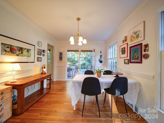 dining area featuring a chandelier, light hardwood / wood-style flooring, and ornamental molding