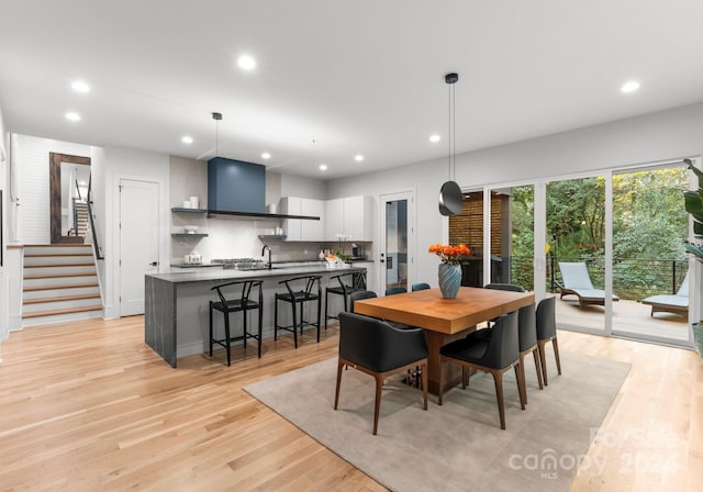 dining area with sink and light hardwood / wood-style floors