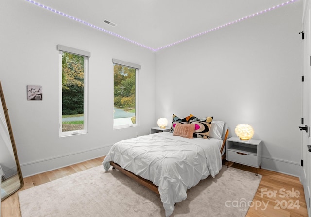 bedroom featuring multiple windows and light hardwood / wood-style floors