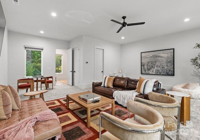 carpeted living room with ceiling fan