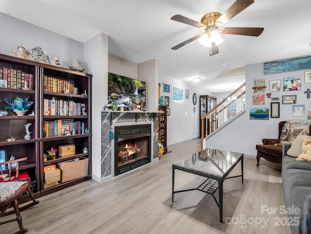 living room with light hardwood / wood-style floors and ceiling fan