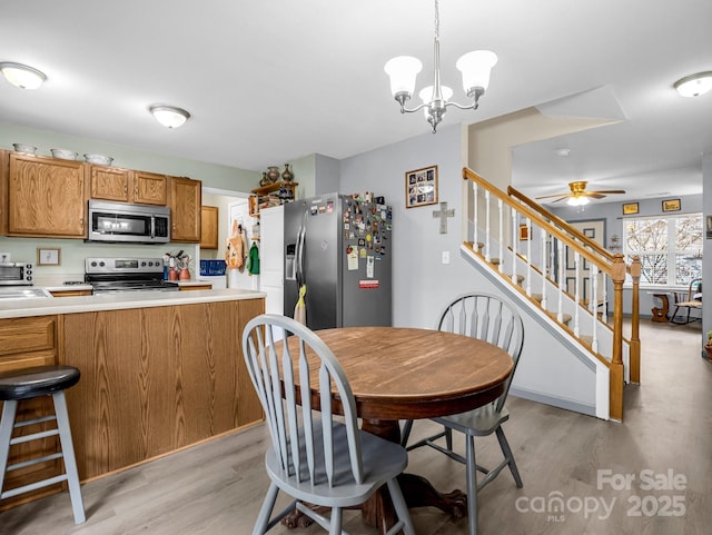 dining room featuring light hardwood / wood-style floors and ceiling fan with notable chandelier