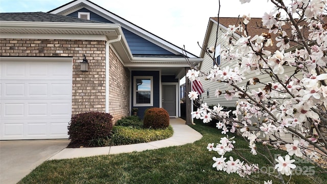 property entrance featuring a garage, brick siding, and a shingled roof