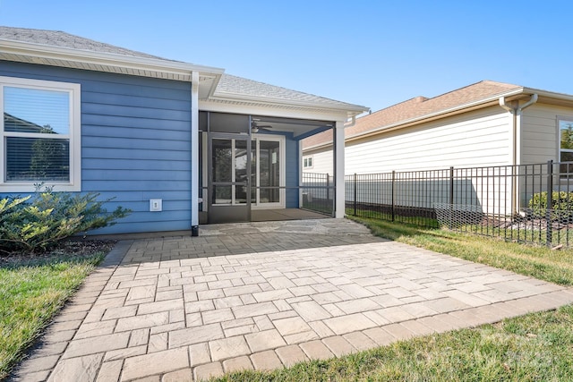 rear view of property with a shingled roof, a ceiling fan, a sunroom, fence, and a patio area