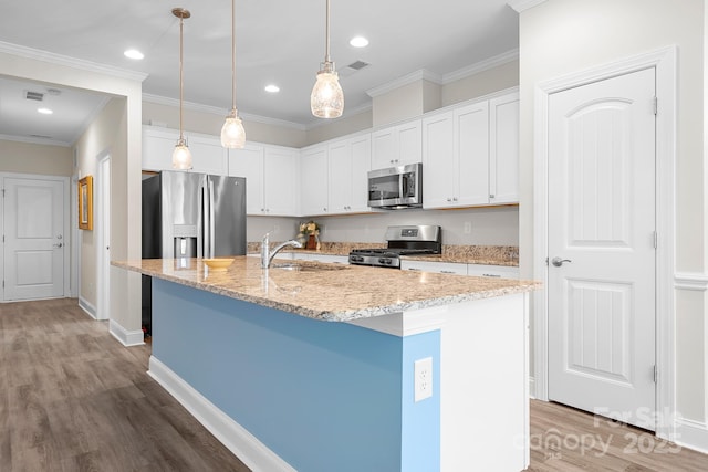 kitchen with stainless steel appliances, wood finished floors, a sink, and white cabinets