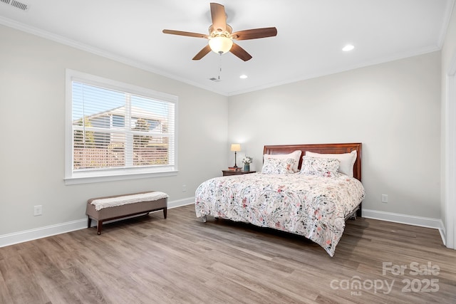 bedroom featuring crown molding, baseboards, and wood finished floors