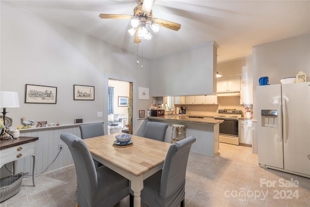 dining space featuring a high ceiling, ceiling fan, and sink