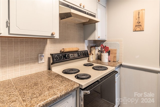 kitchen with white cabinets, tasteful backsplash, and electric range