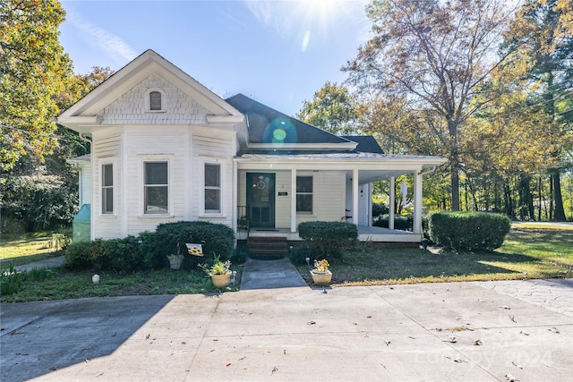 view of front of property with covered porch and a front lawn