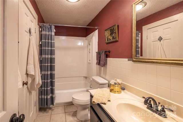 full bathroom featuring toilet, vanity, a textured ceiling, and shower / bath combo with shower curtain