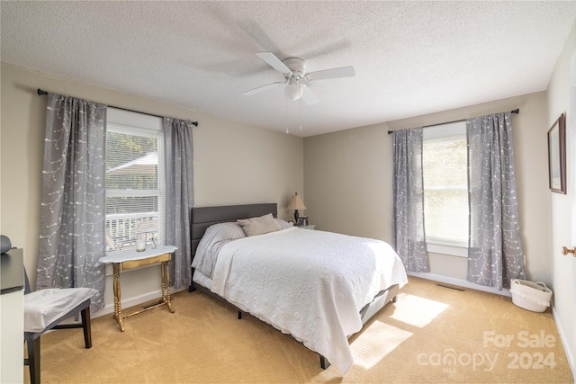 carpeted bedroom with a textured ceiling and ceiling fan