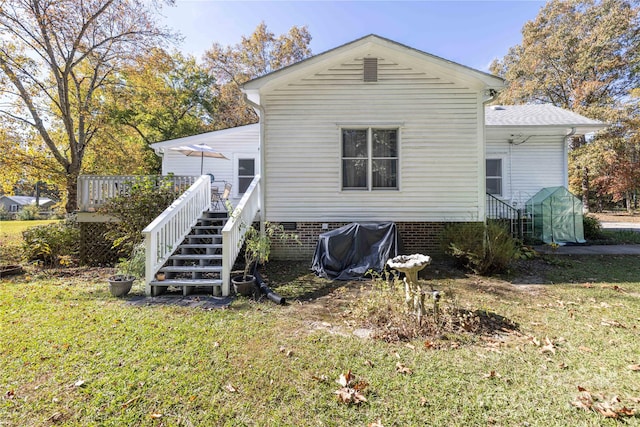 rear view of property with a yard and a deck