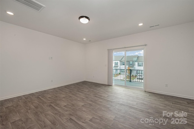 empty room featuring visible vents, baseboards, and wood finished floors