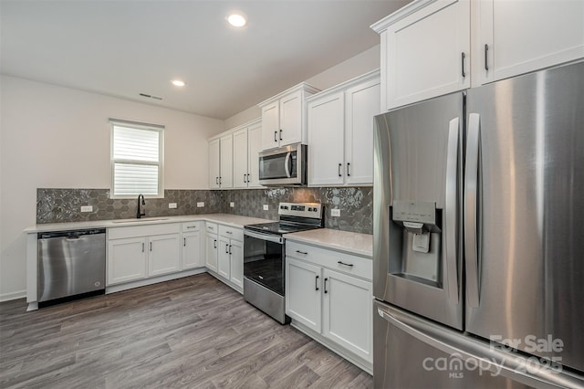 kitchen with stainless steel appliances, visible vents, a sink, and decorative backsplash