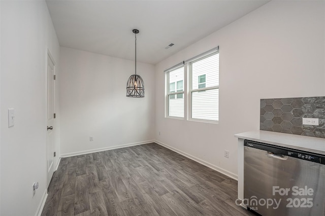 unfurnished dining area featuring dark wood-style floors, visible vents, and baseboards