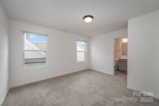 unfurnished bedroom featuring light carpet, connected bathroom, visible vents, and baseboards