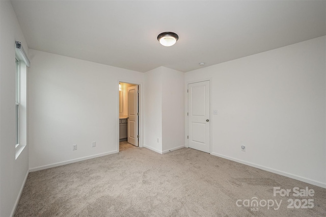 unfurnished room featuring light carpet and baseboards