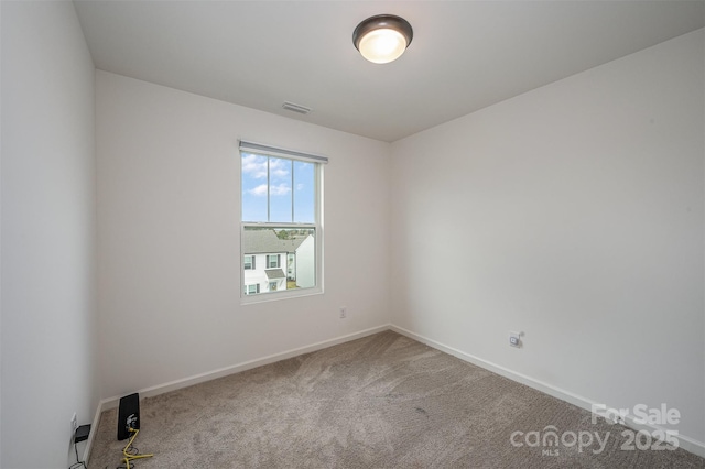 carpeted spare room with visible vents and baseboards