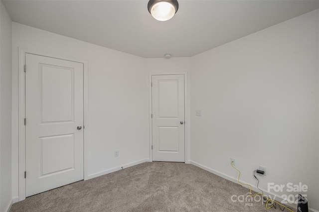 unfurnished room with carpet and baseboards