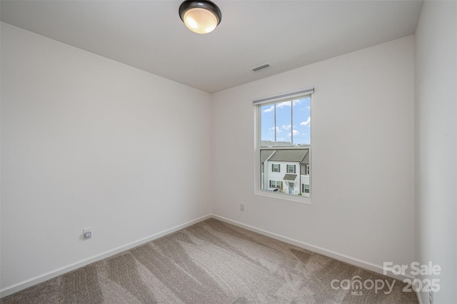 spare room with carpet floors, baseboards, and visible vents