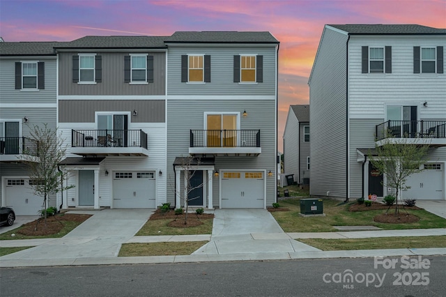 townhome / multi-family property with a garage, cooling unit, and concrete driveway