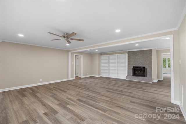 unfurnished living room with crown molding, wood-type flooring, a fireplace, and ceiling fan