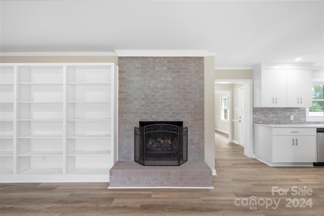 unfurnished living room featuring ornamental molding, a fireplace, and light wood-type flooring