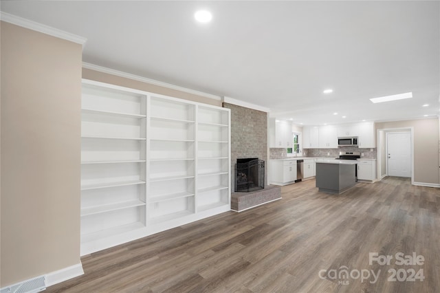 unfurnished living room with crown molding, a fireplace, and wood-type flooring