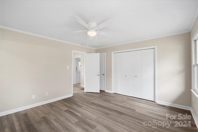 unfurnished bedroom featuring a closet, ornamental molding, light wood-type flooring, and ceiling fan