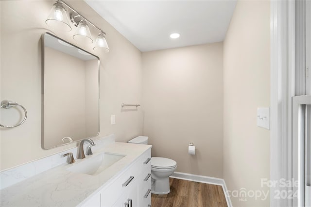 bathroom featuring vanity, hardwood / wood-style floors, and toilet