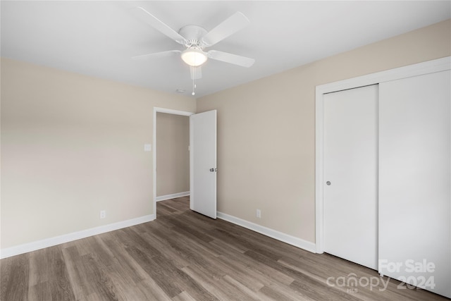 unfurnished bedroom with a closet, ceiling fan, and hardwood / wood-style flooring