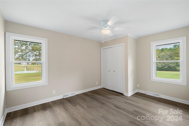 unfurnished bedroom featuring dark hardwood / wood-style floors, a closet, and ceiling fan