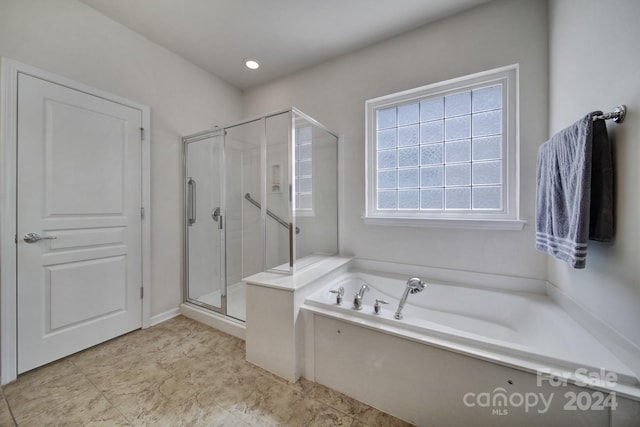 bathroom featuring separate shower and tub