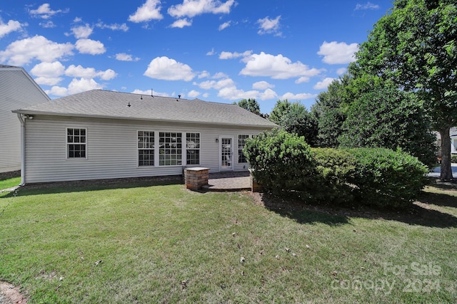 rear view of property featuring a patio area and a lawn