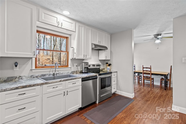 kitchen featuring appliances with stainless steel finishes, a textured ceiling, sink, white cabinets, and dark hardwood / wood-style floors