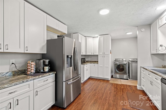 kitchen with white cabinets and washing machine and dryer