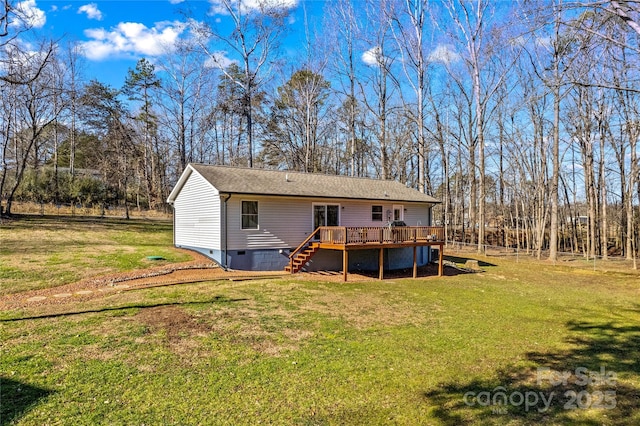 rear view of property featuring a lawn and a wooden deck