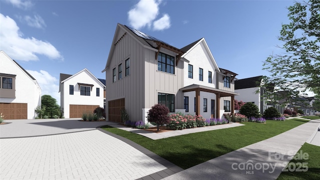 view of front of house featuring driveway, board and batten siding, an attached garage, and a front yard