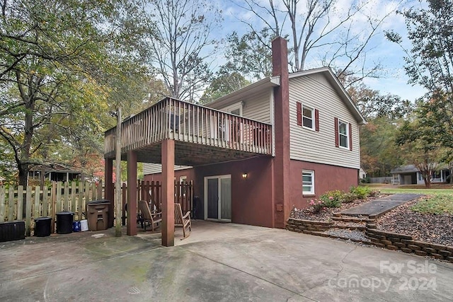 rear view of property featuring a patio and a wooden deck