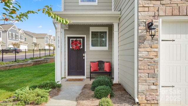 view of exterior entry featuring a lawn