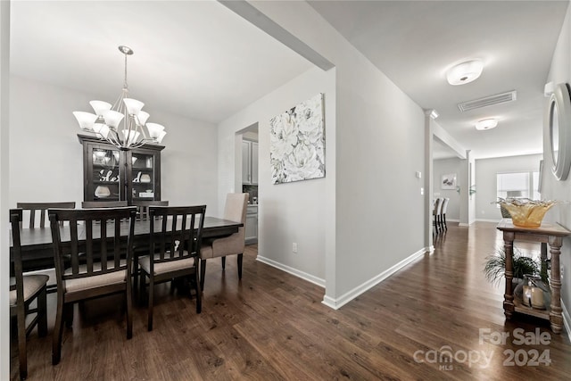 dining area with a chandelier and dark hardwood / wood-style flooring