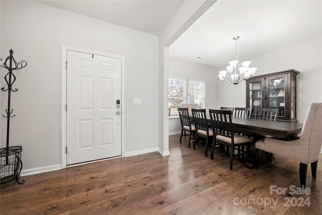 dining space with dark hardwood / wood-style floors and a chandelier