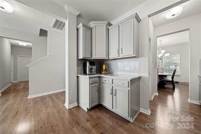 kitchen featuring hardwood / wood-style floors, gray cabinetry, and tasteful backsplash