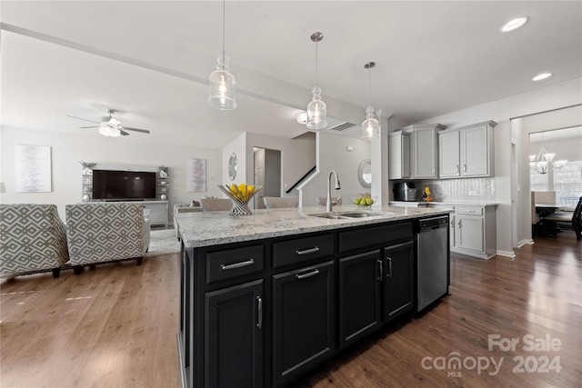 kitchen featuring dark hardwood / wood-style floors, sink, stainless steel dishwasher, and a center island with sink