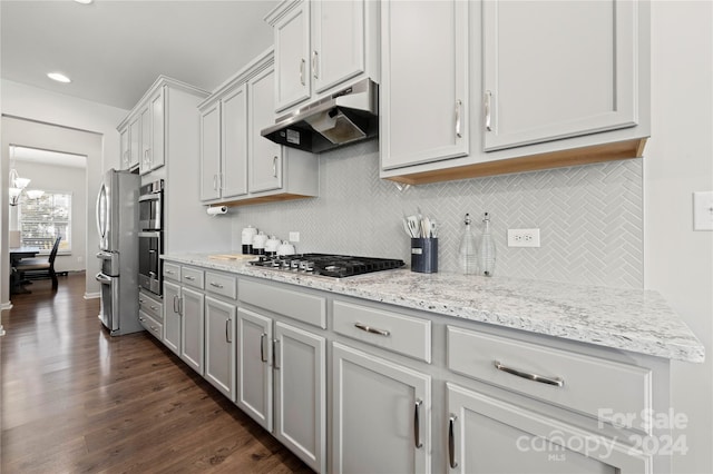 kitchen featuring stainless steel gas stovetop, light stone countertops, tasteful backsplash, and dark hardwood / wood-style flooring