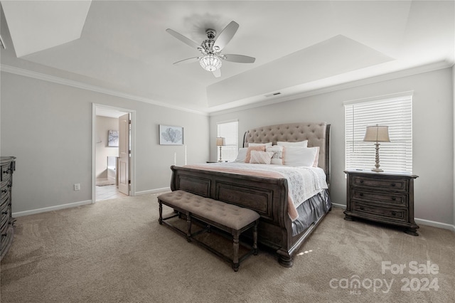 carpeted bedroom featuring connected bathroom, a raised ceiling, multiple windows, and ceiling fan